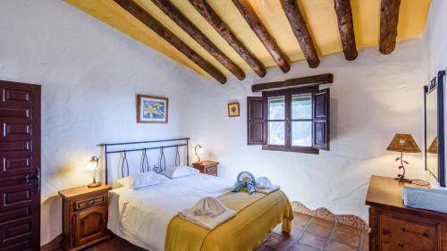 Schlafzimmer mit einem Bett und einem Fenster in der Unterkunft Finca Carrulo Competa by Ruralidays in Cómpeta