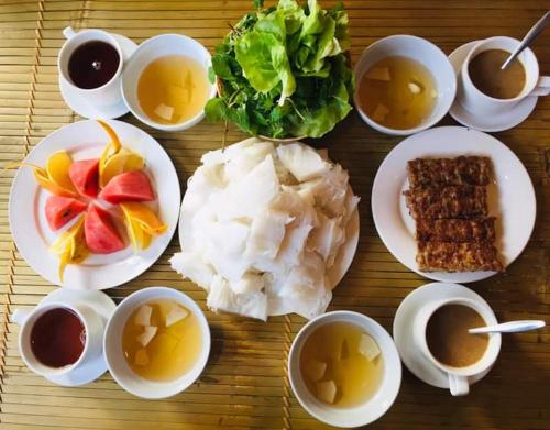 a table with plates of food and bowls of soup at Hang Múa Village Homestay in Ninh Binh