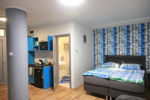 um pequeno quarto com uma cama e uma casa de banho em Studio Gold apartman em Pécs