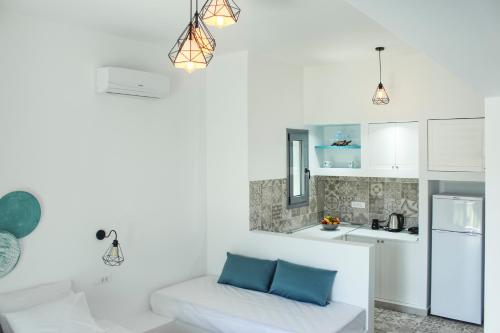 a white kitchen with a couch in a room at Haraki Sea & Sun in Haraki