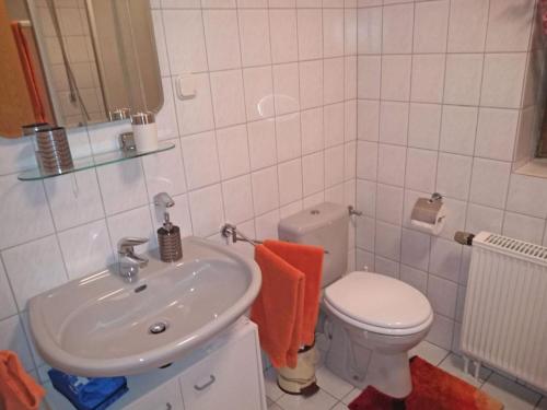 a bathroom with a white toilet and a sink at Ferienwohnung Mauer in Neuenrade