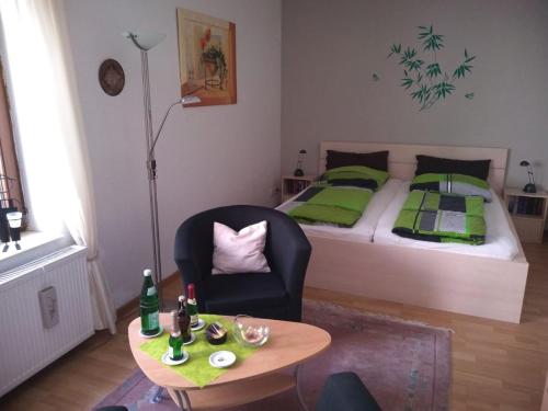 a bedroom with a bed and a chair and a table at Ferienwohnung Mauer in Neuenrade