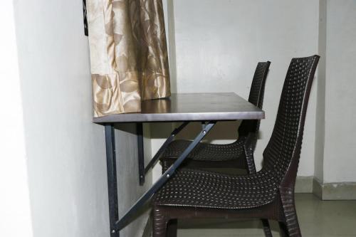 a table with two chairs and a curtain at S4 Residency in Chennai