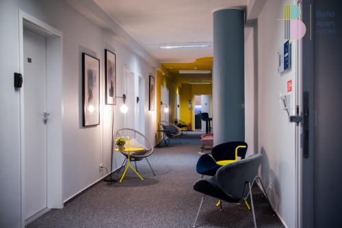 a corridor of an office with chairs and a table at Bello ApartHostel in Warsaw