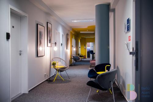 a corridor of an office with chairs and a table at Bello ApartHostel in Warsaw