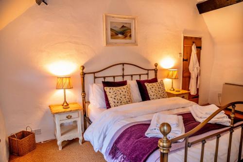 a bedroom with a large bed with two lamps at Finest Retreats - Little Haven in Minehead