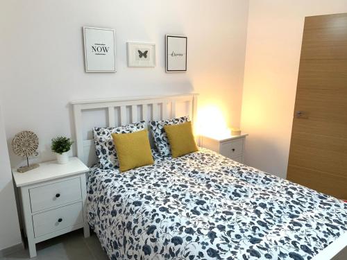 Schlafzimmer mit einem Bett mit einer blauen und weißen Bettdecke in der Unterkunft UIM Mediterraneo PB Aragon B Wifi in Puerto de Sagunto