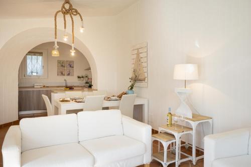 a living room with a white couch and a table at BGItalianVacation - Ville Li Conchi in Castiadas