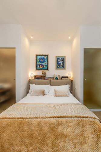 a bedroom with a large bed with two pictures on the wall at Masseria Limonaia & Spa in Fasano
