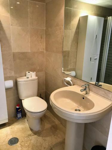 a bathroom with a toilet and a sink and a mirror at Sunny Escape by the Sea & Yacht Club in Altea