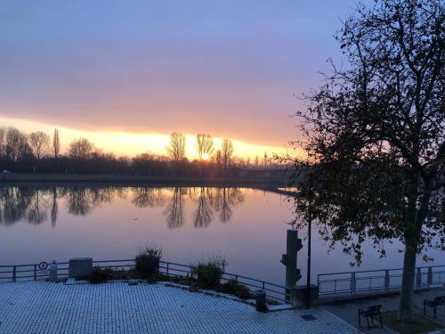 a large body of water with a sunset in the background at Best Western Plus d'Europe et d'Angleterre in Mâcon