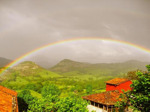 a rainbow in the sky over a mountain at Hotel Rural El Rexacu in Bobia de Arriba