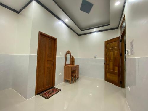 a bathroom with a toilet and a wooden door at Tùng Thủy Homestay - Dinh Thầy Thím Lagi in La Gi