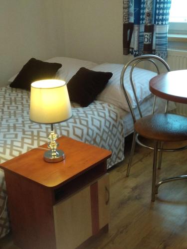 a lamp on a table next to a bed at Tęczowy Poranek in Ustrzyki Dolne