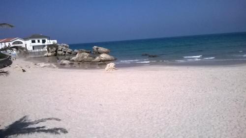 a white sandy beach with a house and the ocean at Hotel Baleal Spot in Baleal