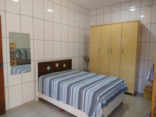 a small bedroom with a bed and a cabinet at Espaço coração de mãe in Pirapòzinho