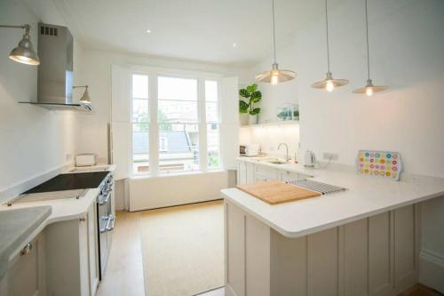 a kitchen with white cabinets and a white counter top at Blenheim House - Luxury City Centre Georgian Townhouse for 8 in Bath