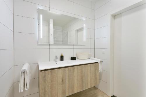 a white bathroom with a sink and a mirror at Verac Flats in Zaventem