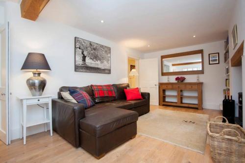 a living room with a brown leather couch and a table at The Bath Retreat in Bath