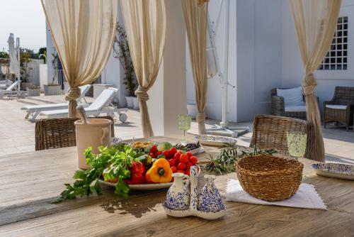 a table with a plate of fruit and vegetables on it at Masseria Limonaia & Spa in Fasano