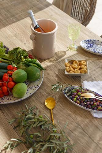 a table with plates of fruits and vegetables on it at Masseria Limonaia & Spa in Fasano
