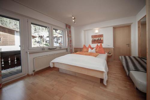 Un dormitorio con una gran cama blanca con almohadas naranjas. en Haus Ingrid, en Sölden