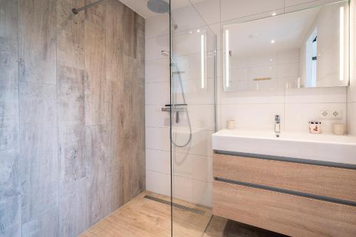 a bathroom with a sink and a shower at Appartementencomplex Juliana 176 in De Koog
