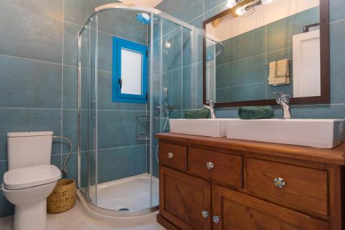 a bathroom with a toilet and a sink and a shower at Indigo Villa in Agios Nikolaos