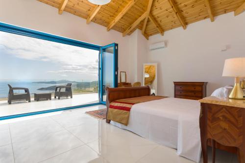 a bedroom with a bed and a view of the ocean at Indigo Villa in Agios Nikolaos
