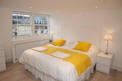 a bedroom with a large bed with yellow pillows at Spectacular views, 1 Bed Central Bath Apartment in Bath