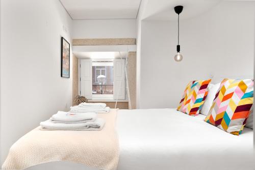a bedroom with a white bed with towels on it at Liiiving in Porto - Santa Catarina Boutique in Porto