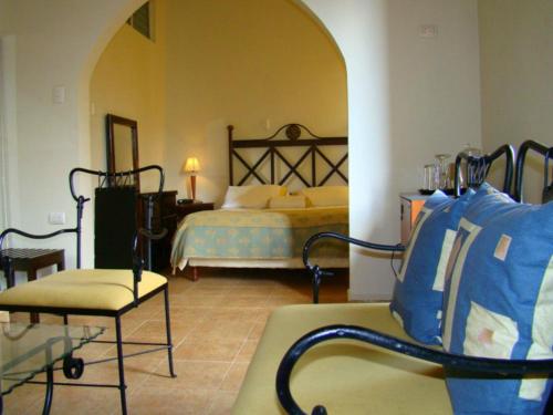 1 dormitorio con 1 cama y 1 silla en una habitación en Hotel Plaza CA, en Mérida