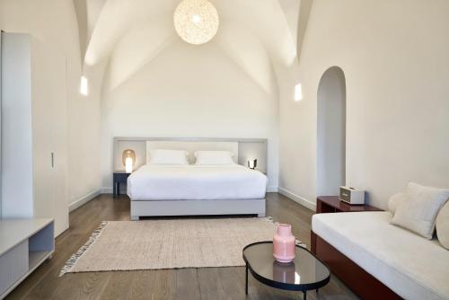 a bedroom with a white bed and a couch at Old Castle Oia in Oia