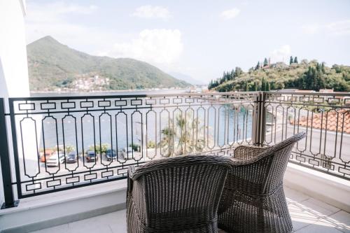 a wicker chair sitting on a balcony with a view at Boutique Hotel & Spa Casa del Mare - Mediterraneo in Herceg-Novi