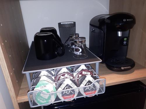- une étagère avec une cafetière et des tasses à café dans l'établissement SPA privatif Love room, Le Hammam et Bulles, chez Nuits Chartraines, à Chartres