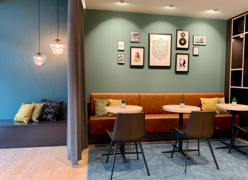 a restaurant with two tables and a couch at zeitwohnhaus SUITE-HOTEL & SERVICED APARTMENTS in Erlangen