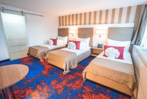 um quarto de hotel com duas camas e uma mesa em My Home Hotel - Free Parking em Winterthur