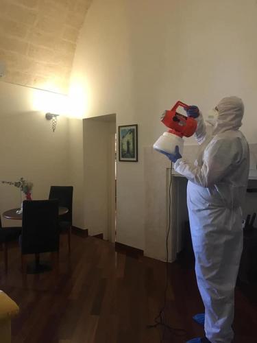 a person in a white suit holding a red toy at Alla dimora di Chiara Suite and Rooms in Matera