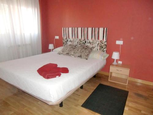 una camera con un letto bianco con una parete rossa di Welcoming apartment in Zamora, 83 sqm, balcony with view a Zamora