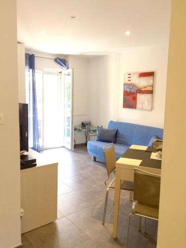 un salon avec un canapé bleu et une table dans l'établissement Appartement charmant à Galéria avec vue sur mer, 39 m², à Galéria