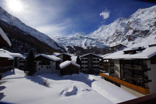 a snow covered village with mountains in the background at Haus Amor in Saas-Fee