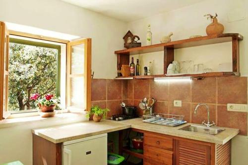 a kitchen with a sink and a window at Charming House Selca + BBQ in Selca