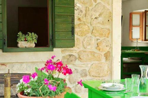 a table with a potted plant and a stone wall at Charming House Selca + BBQ in Selca