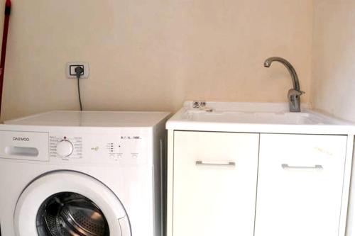 a laundry room with a washing machine and a sink at Charming house in Scicli with jacuzzi in Scicli