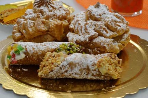 a plate of pastries and donuts on a table at Charming house in Scicli with jacuzzi in Scicli