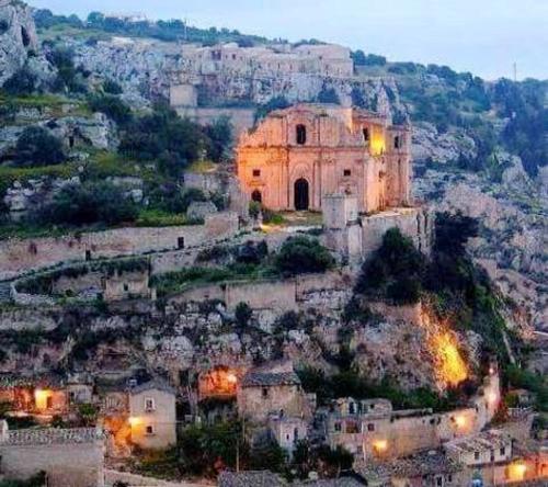 an old building on top of a hill with a city at Charming house in Scicli with jacuzzi in Scicli