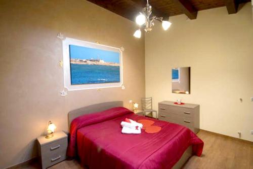 a bedroom with a red bed with a stuffed animal on it at Charming house in Scicli with jacuzzi in Scicli