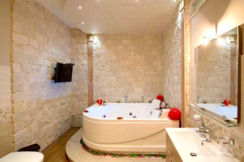 a bathroom with a tub and a sink and a toilet at Charming house in Scicli with jacuzzi in Scicli