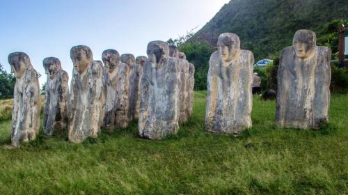 a group of statues sitting in the grass at Maison charmante aux Anses-d'Arlet avec vue sur la mer in Les Anses-dʼArlets