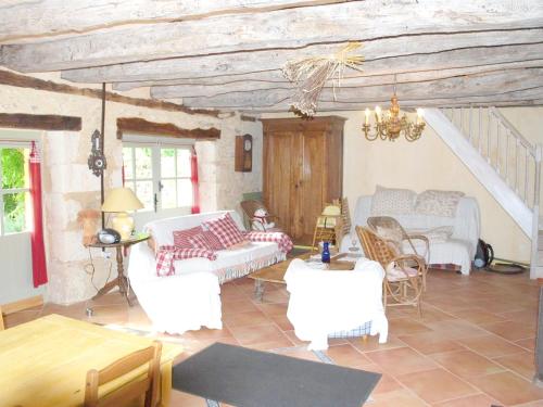 uma sala de estar com mobiliário branco e tectos em madeira em Maison d'une chambre avec piscine privee jardin amenage et wifi a Sainte Alvere em Saint-Alvère